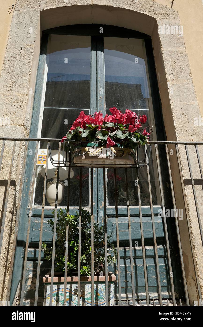Italia, Sicilia, Caltagirone, finestra francese in vecchio stile dietro un piccolo balcone sopra le scale in una strada Foto Stock
