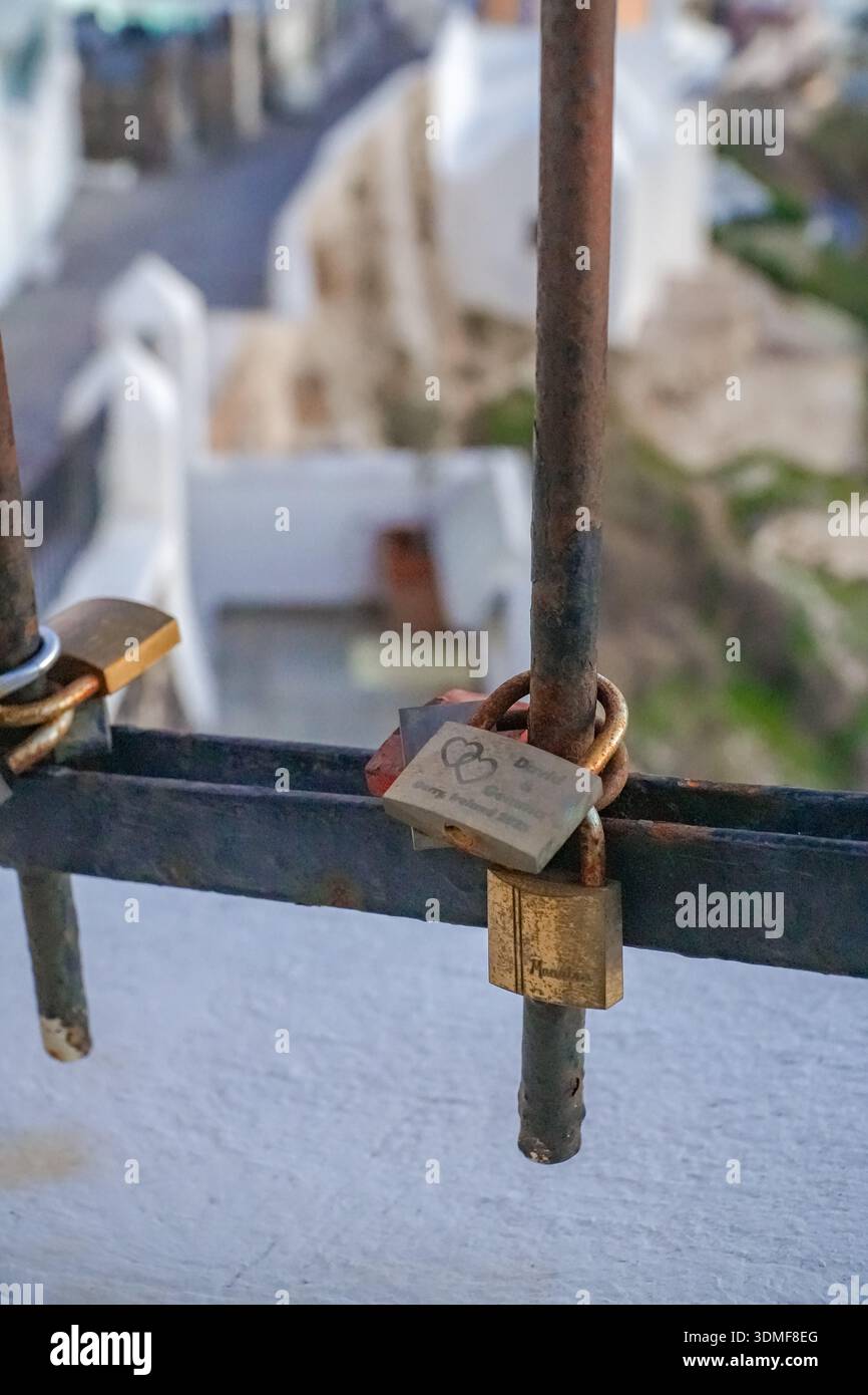 Lucchetti d'amore appesi su una ringhiera metallica intemprata a Fira (Thira), Santorini. Simbolo di un'eterna storia d'amore e di ricordi di viaggio. Foto Stock