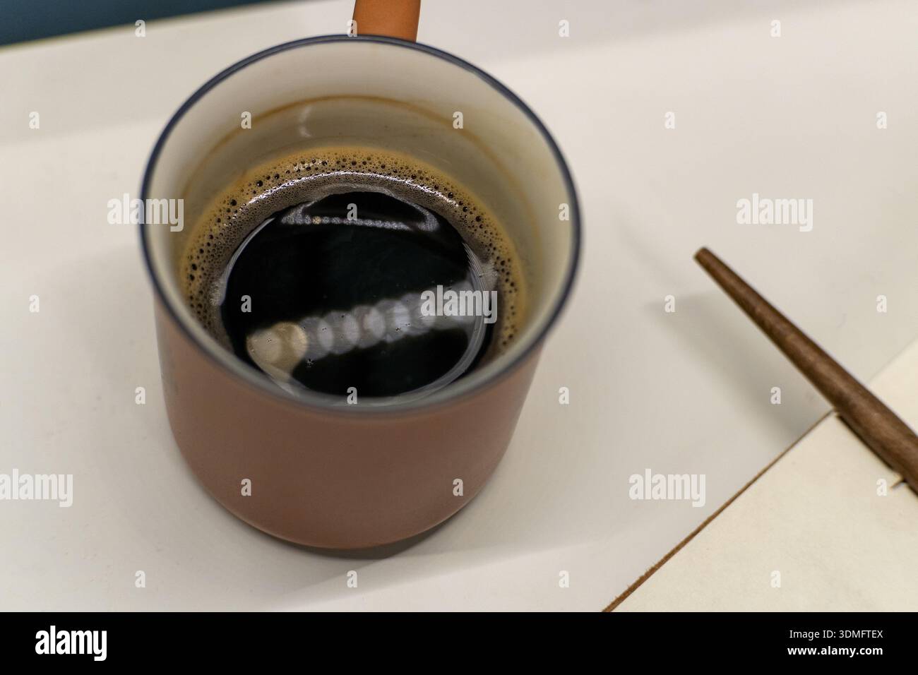 Comoda scrivania con tazza da caffè e notebook aperto Foto Stock