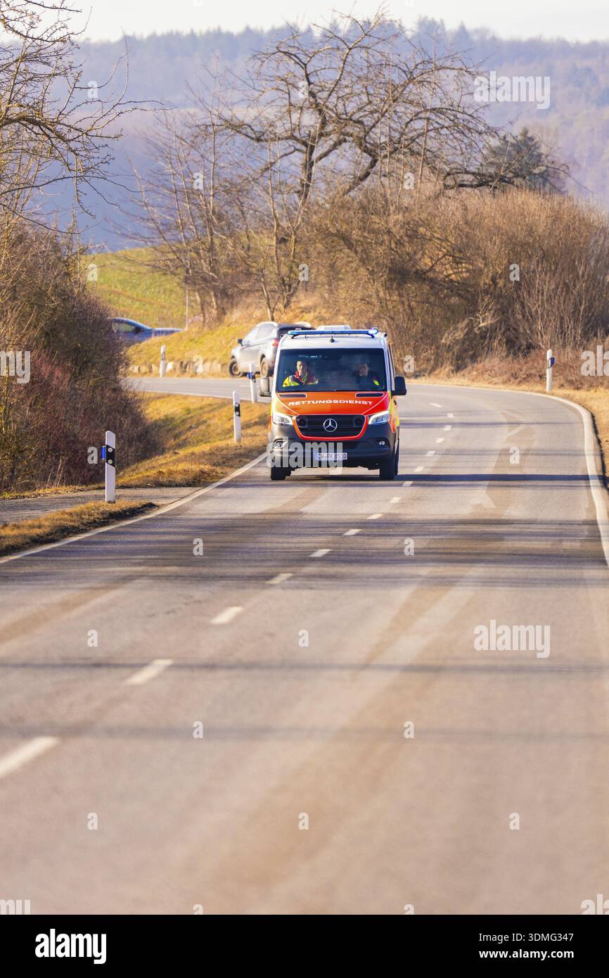 Un'ambulanza percorre una strada di campagna vuota, esercitazione dei vigili del fuoco sulla ferrovia Hermann Hesse, Ostelsheim, Germania Foto Stock