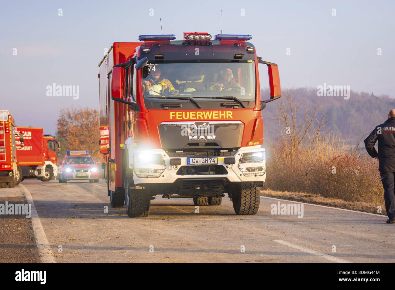 Un camion dei vigili del fuoco guida su una strada attraverso un'area boscosa con personale di emergenza, esercitazione dei vigili del fuoco presso la ferrovia Hermann Hesse, Ostelsheim, Calw dis Foto Stock