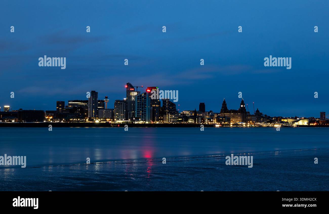Skyline di Liverpool all'alba con le luci della città che si riflettono sulle calme acque del fiume Mersey Foto Stock