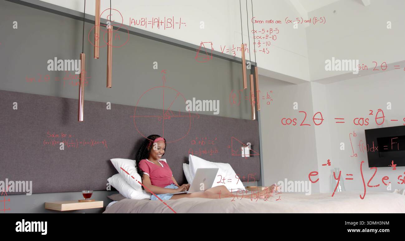 Donna che studia con una t-shirt color marrone utilizzando un laptop argentato sul letto in camera da letto, con sovrapposizioni matematiche rosse Foto Stock