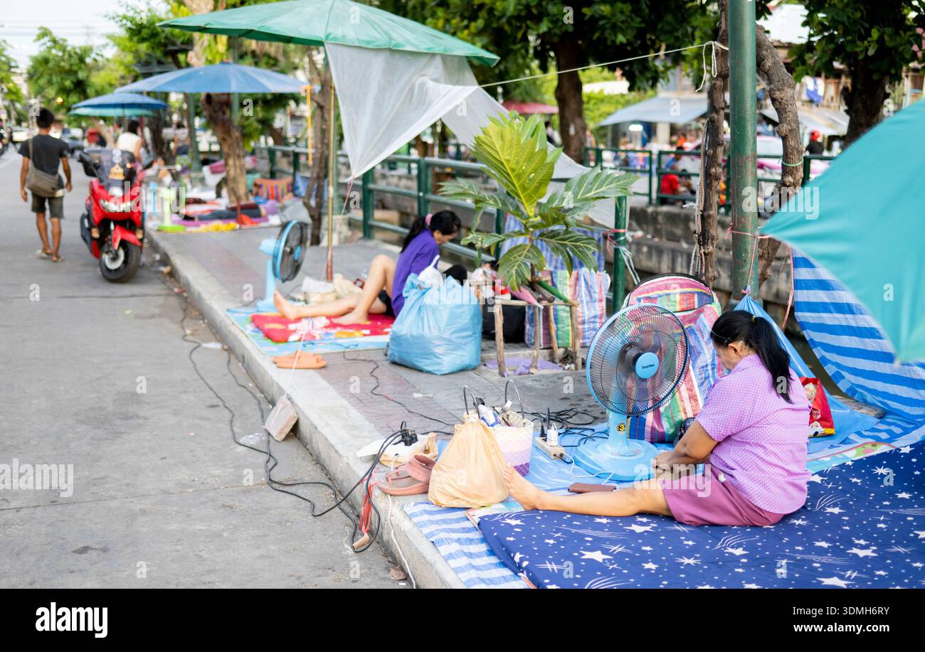 Bangkok-aprile 26 2025:dopo la pandemia, molti altri senzatetto vivono ora nella capitale della Thailandia, qui con un po' di accesso all'elettricità, molti tra cui Foto Stock