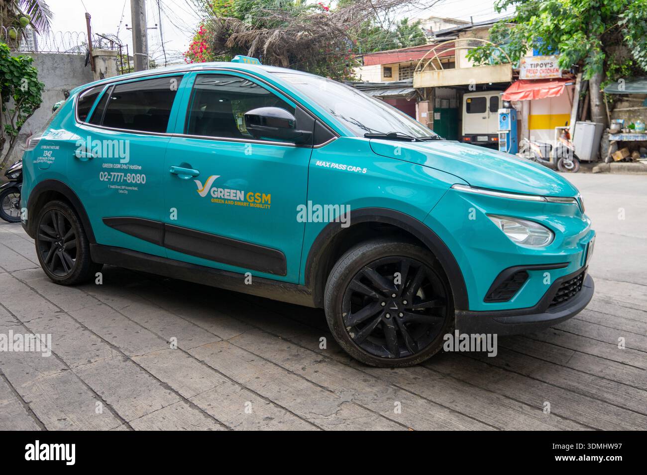 Taxi elettrico Green GSM parcheggiato in strada a Cebu, Filippine, che riflette la crescita del trasporto elettrico e la mobilità urbana sostenibile. Foto Stock