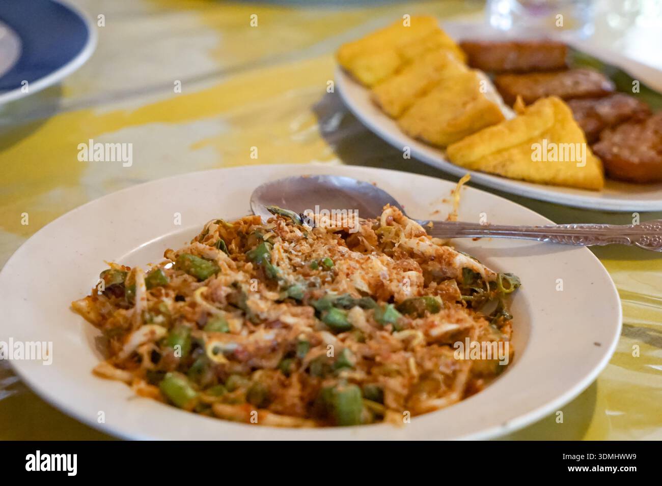 Tradizionale insalata di Lotek Sundanese con verdure al vapore, salsa di arachidi piccante, tofu e tempeh serviti su tovaglie a motivi geometrici. Foto Stock