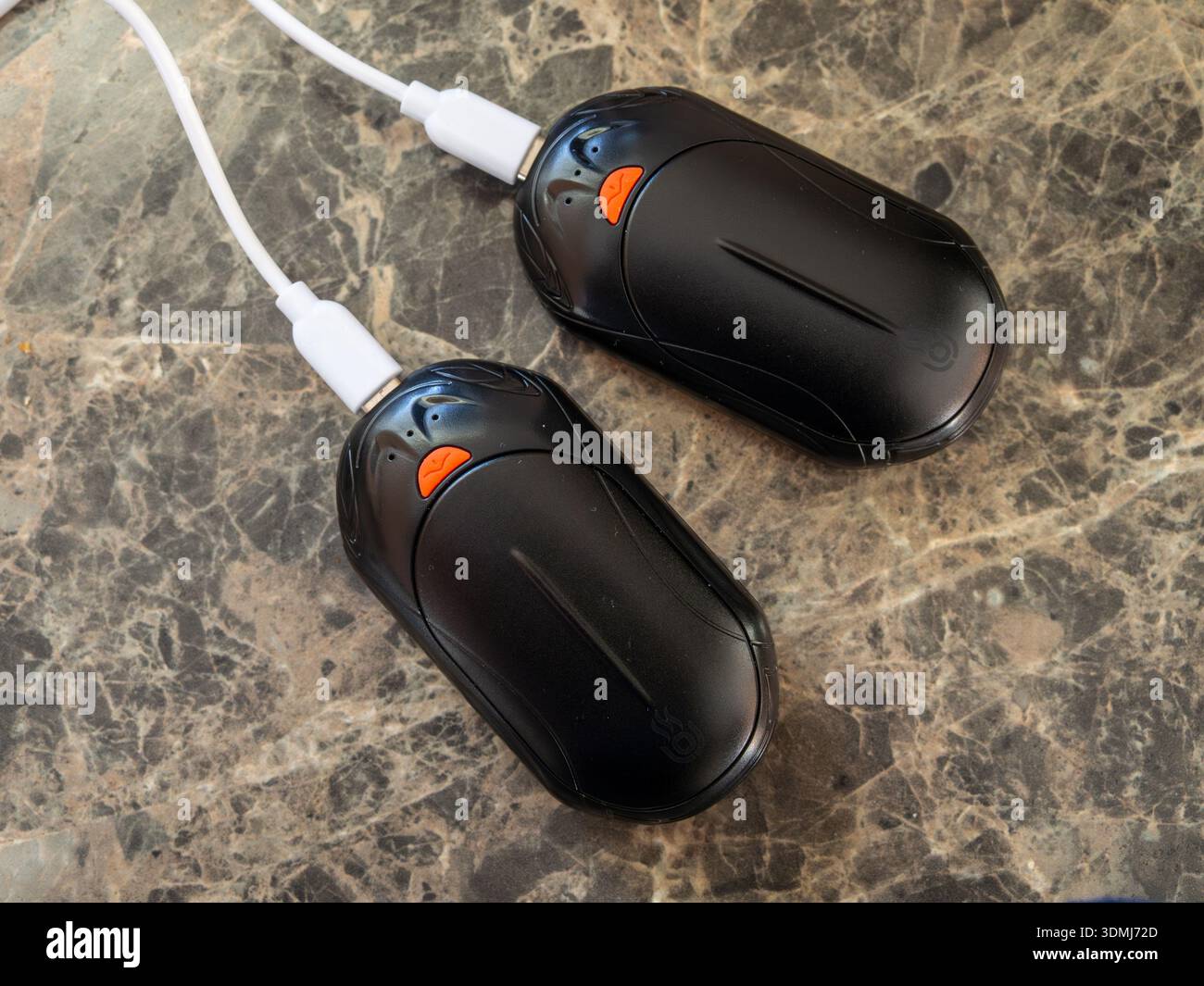 Cavi per la ricarica di due riscaldatori manuali a batteria, Regno Unito Foto Stock
