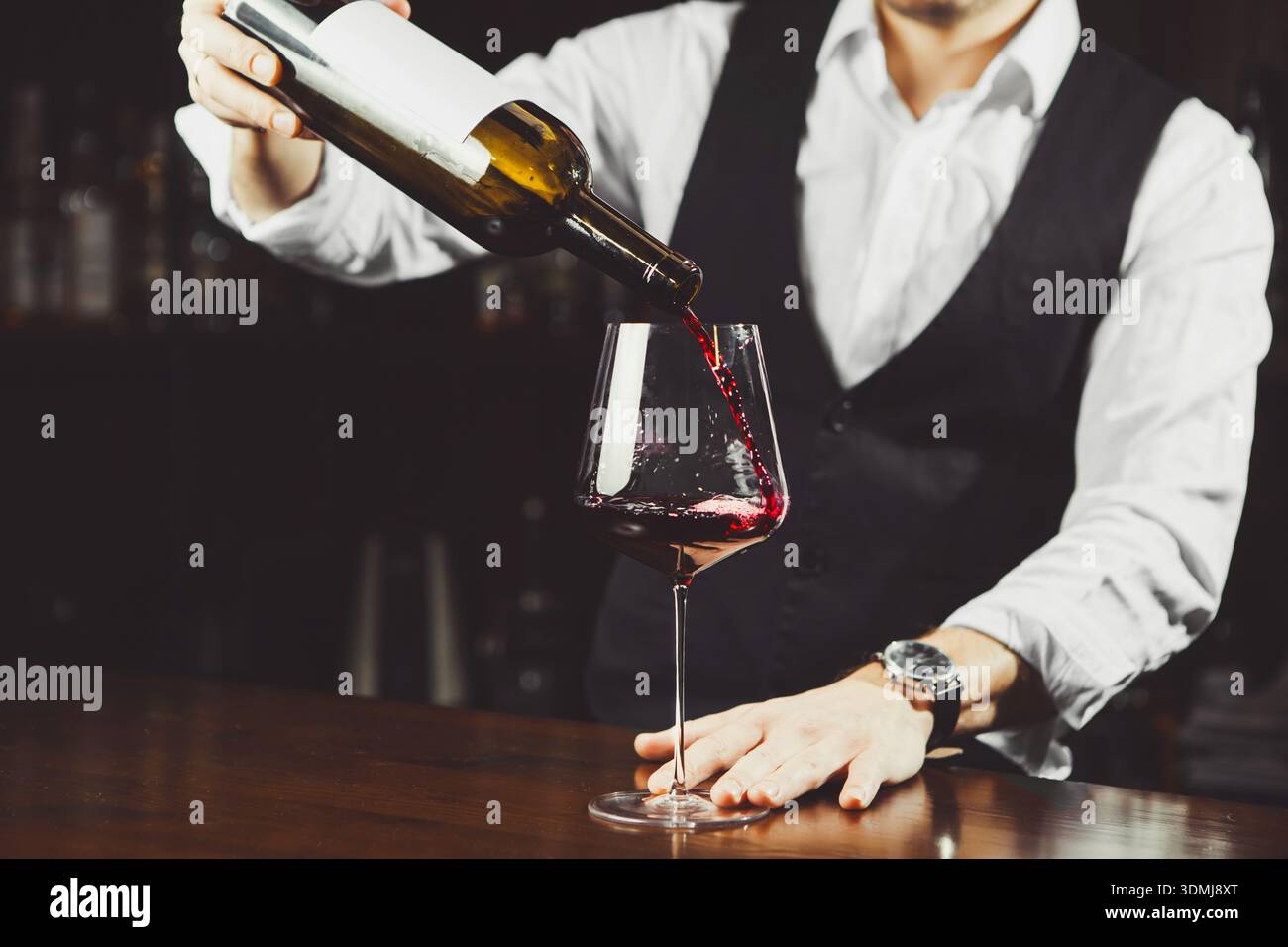 Primo piano di un bicchiere con vino versato dal sommelier Foto Stock