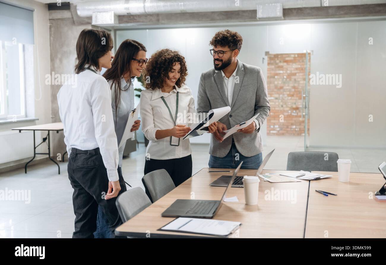 I dipendenti intelligenti stanno conversando. Un gruppo di persone lavora in ufficio insieme come un team. Foto Stock