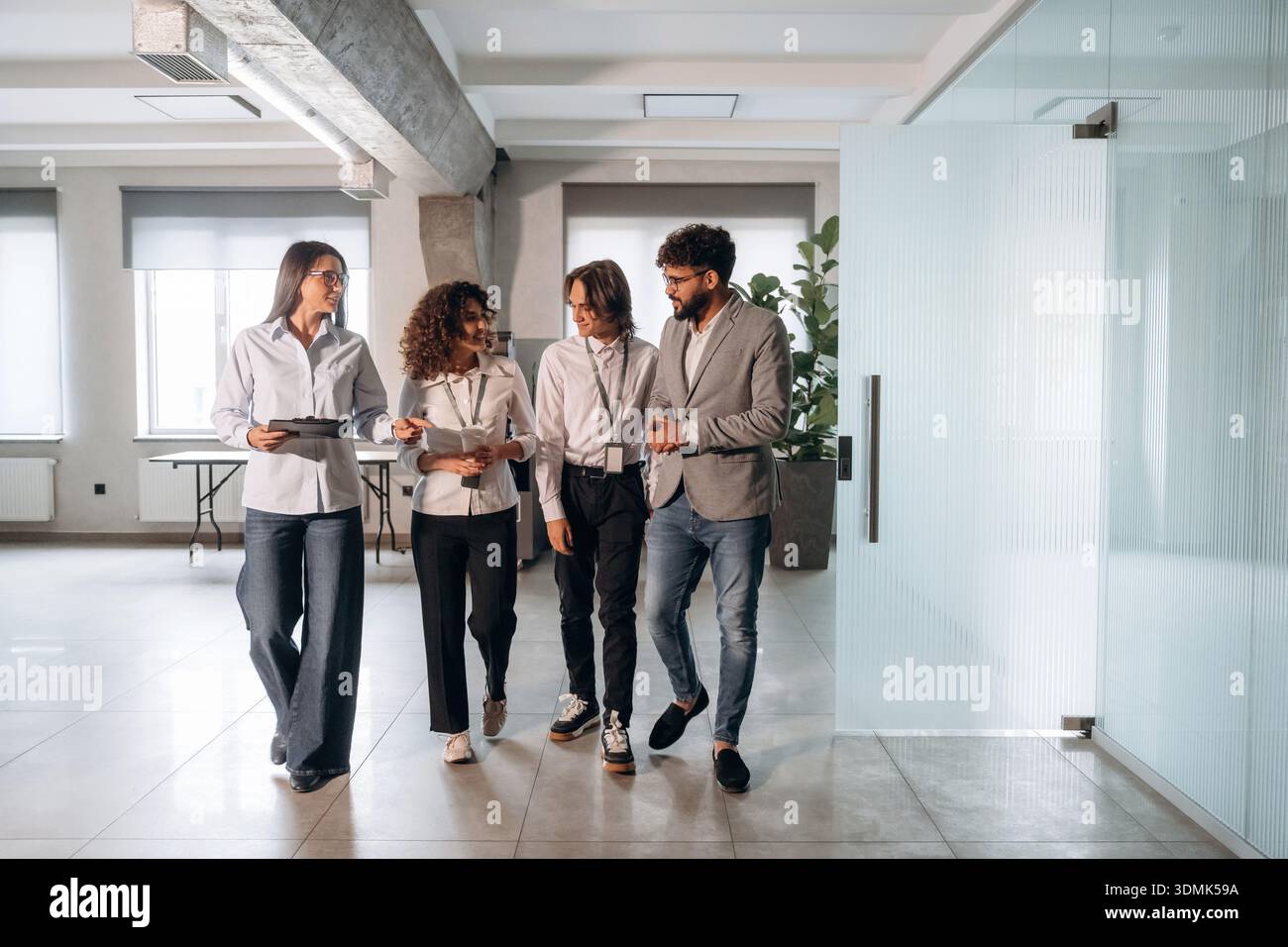 Nel corridoio. Quattro impiegati sono insieme, impiegati al lavoro. Foto Stock