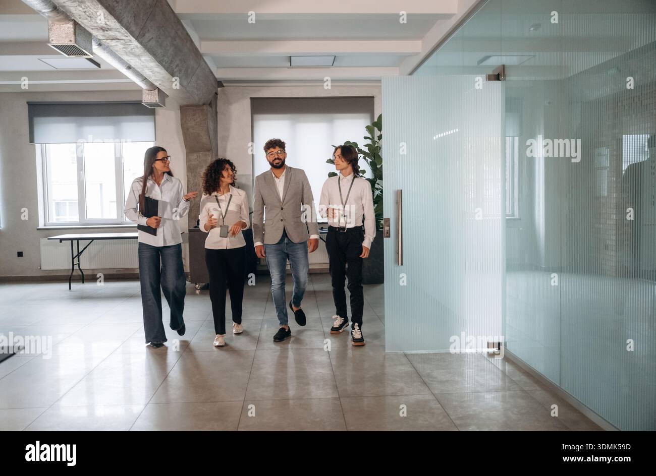 Nel corridoio. Quattro impiegati sono insieme, impiegati al lavoro. Foto Stock