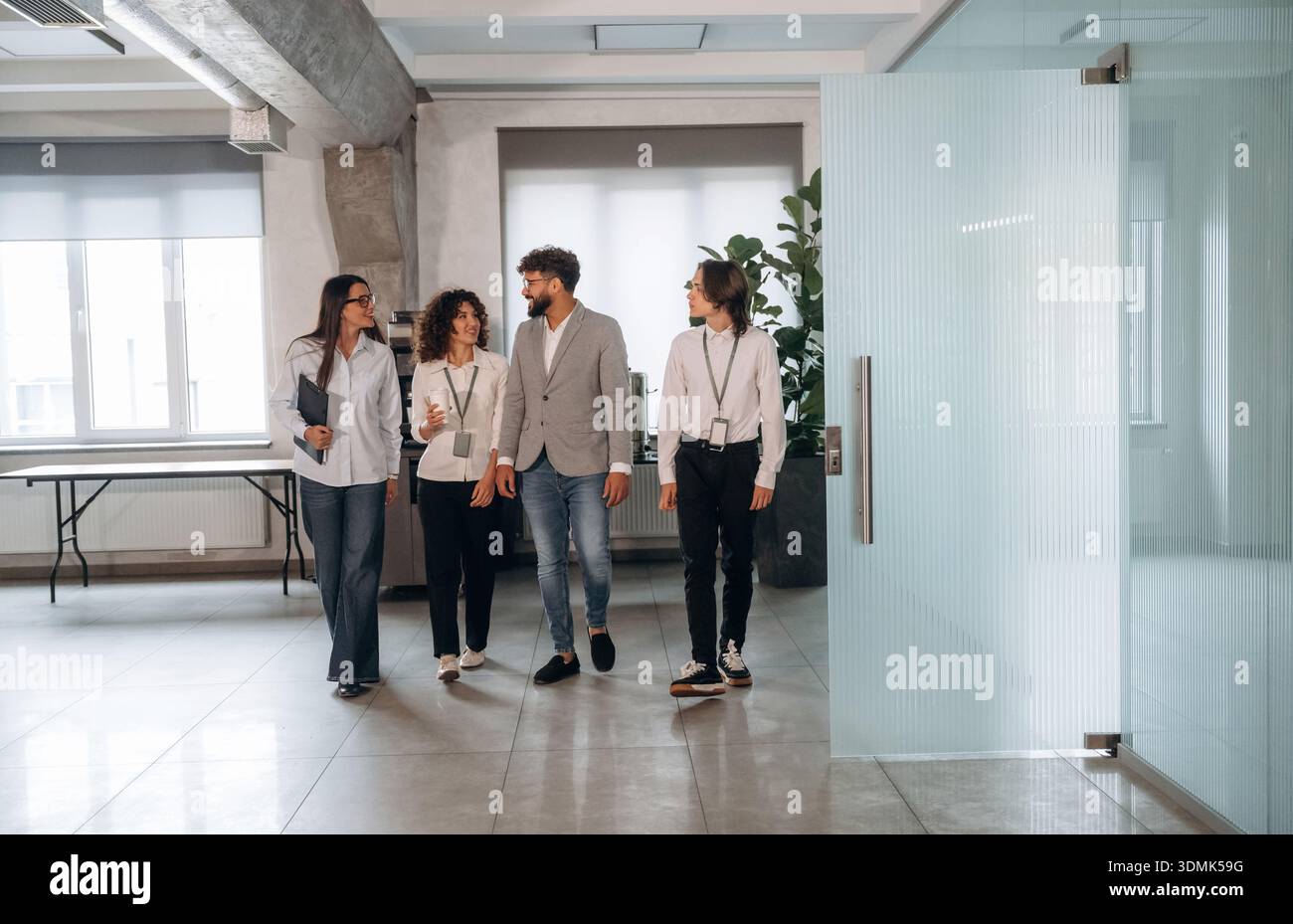 Nel corridoio. Quattro impiegati sono insieme, impiegati al lavoro. Foto Stock