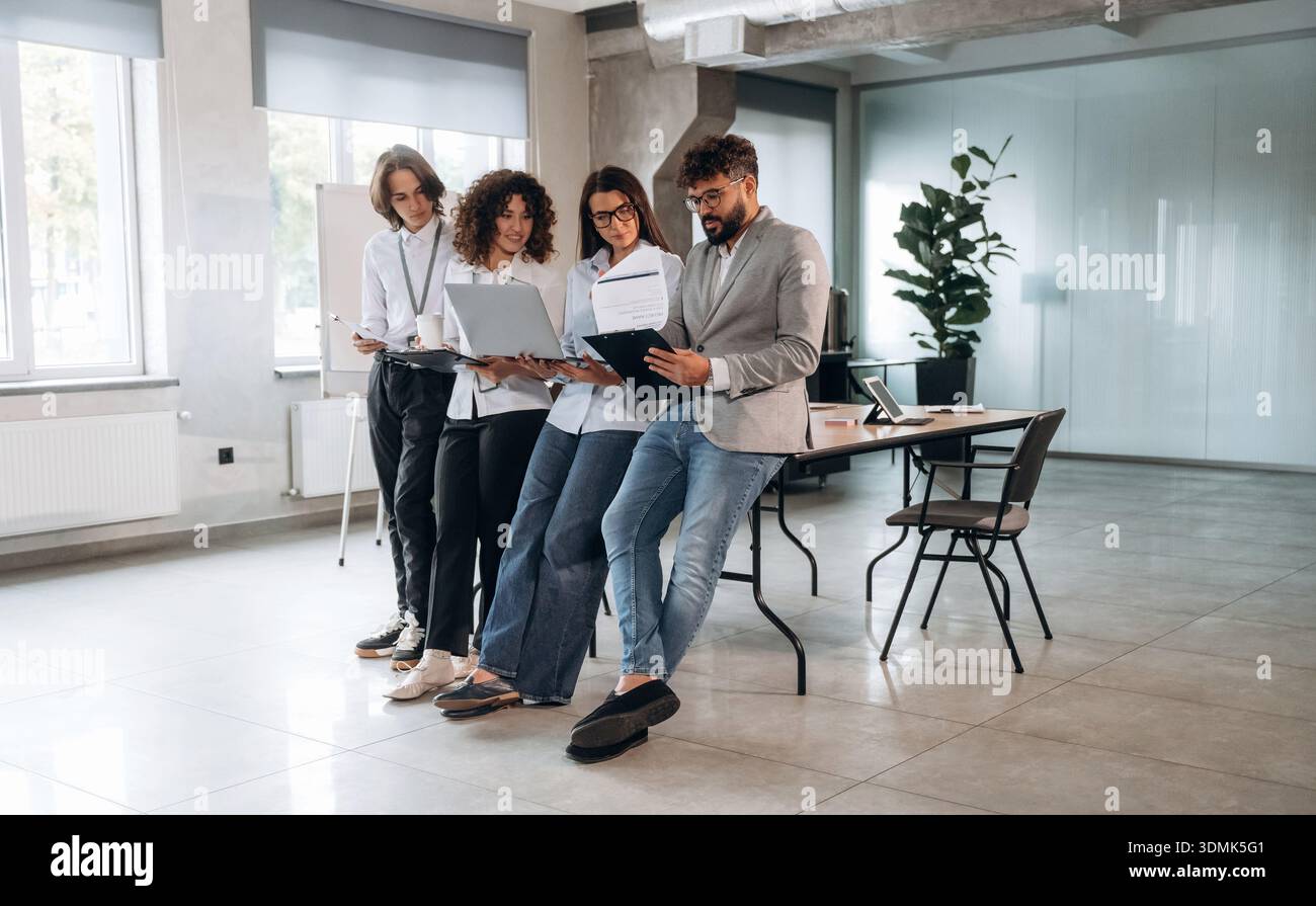 Lettura delle informazioni. Un gruppo di persone lavora in ufficio insieme come un team. Foto Stock