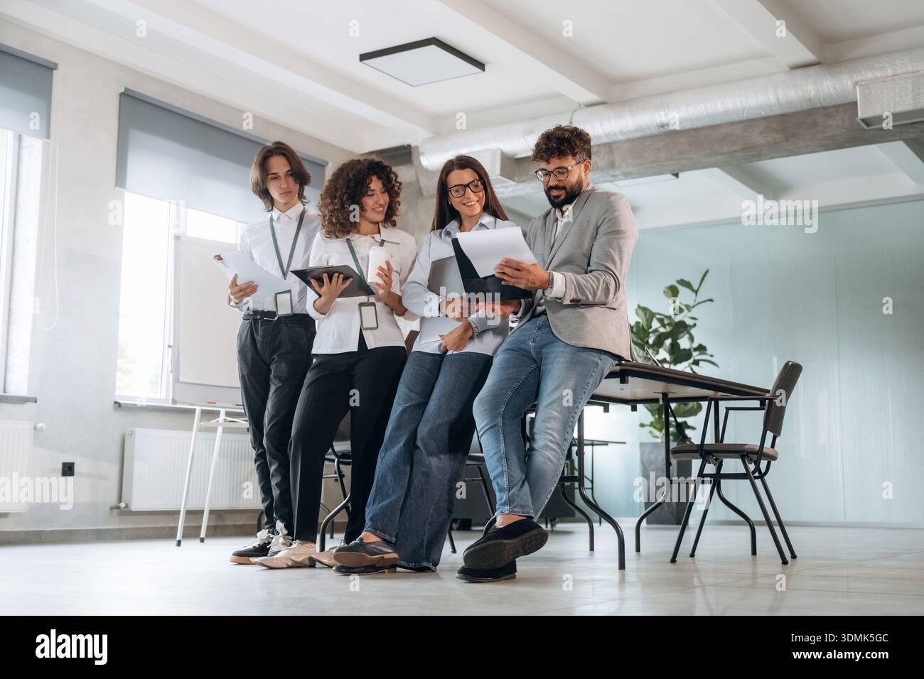 Illuminazione naturale. Un gruppo di persone lavora in ufficio insieme come un team. Foto Stock