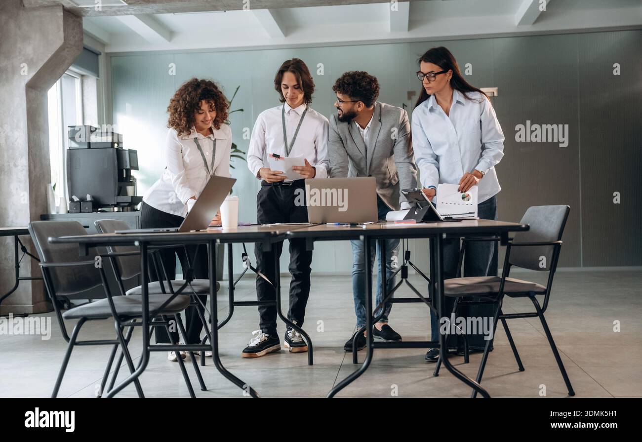 Avere una conversazione. Un gruppo di persone lavora in ufficio insieme come un team. Foto Stock
