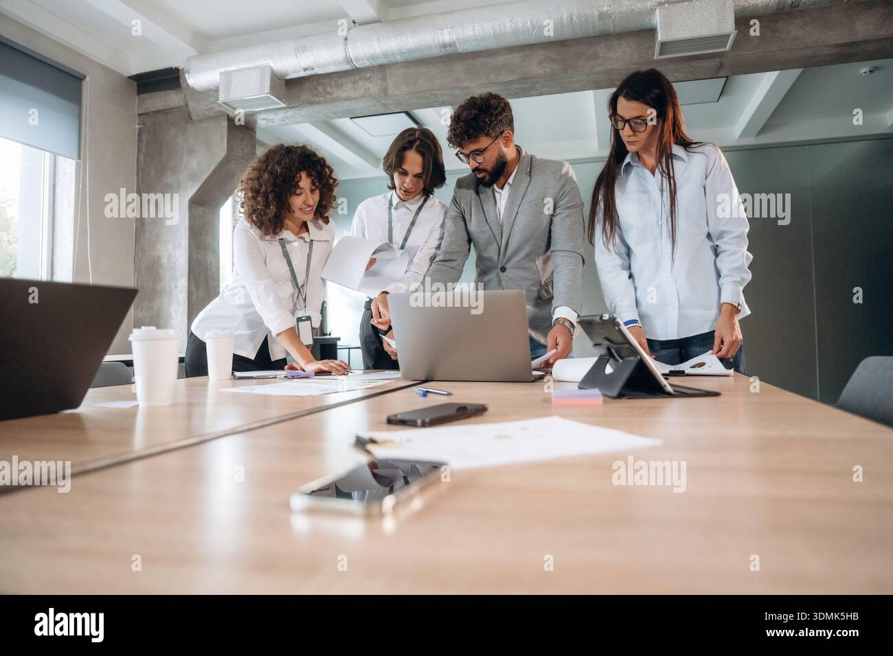 Giornata piena, vicino al tavolo. Un gruppo di persone lavora in ufficio insieme come un team. Foto Stock