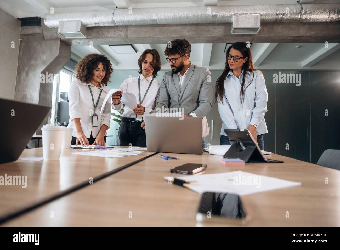 Giornata piena, vicino al tavolo. Un gruppo di persone lavora in ufficio insieme come un team. Foto Stock