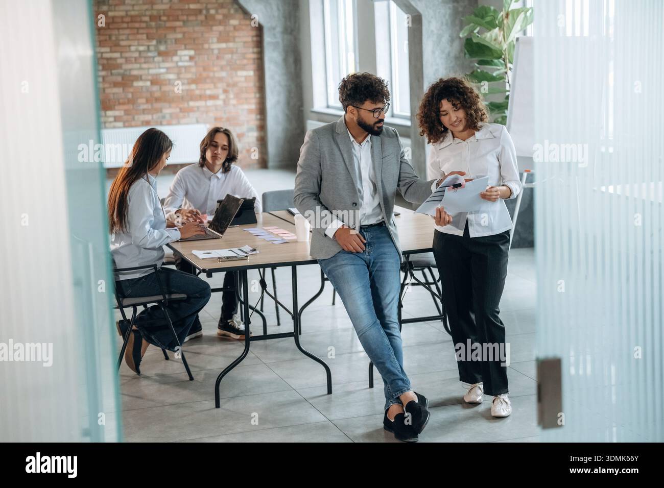 Appoggiato sul tavolo. Un gruppo di persone lavora in ufficio insieme come un team. Foto Stock