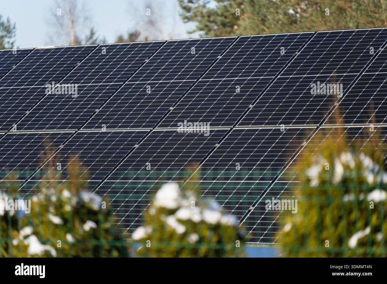 Vista dettagliata dei moduli solari neri sul tetto residenziale, array di pannelli angolati con struttura cellulare, tecnologia elettrica sostenibile nella stagione fredda Foto Stock