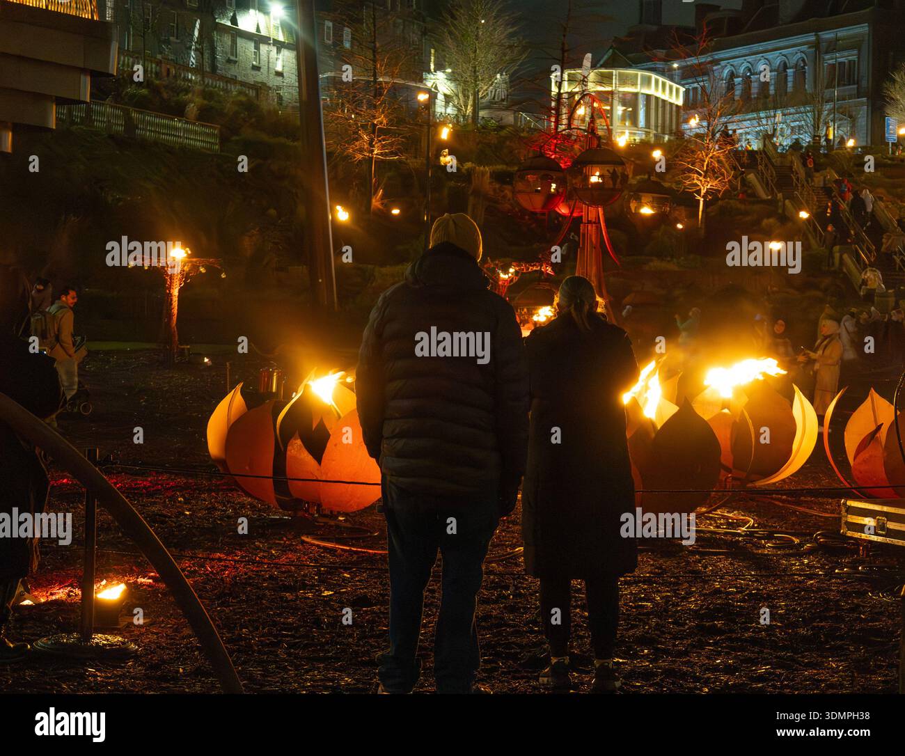 Persone che guardano una delle installazioni nel Fire Garden by Walk the Plank negli Union Terrace Gardens durante lo Spectra Festival of Light Aberdeen Foto Stock
