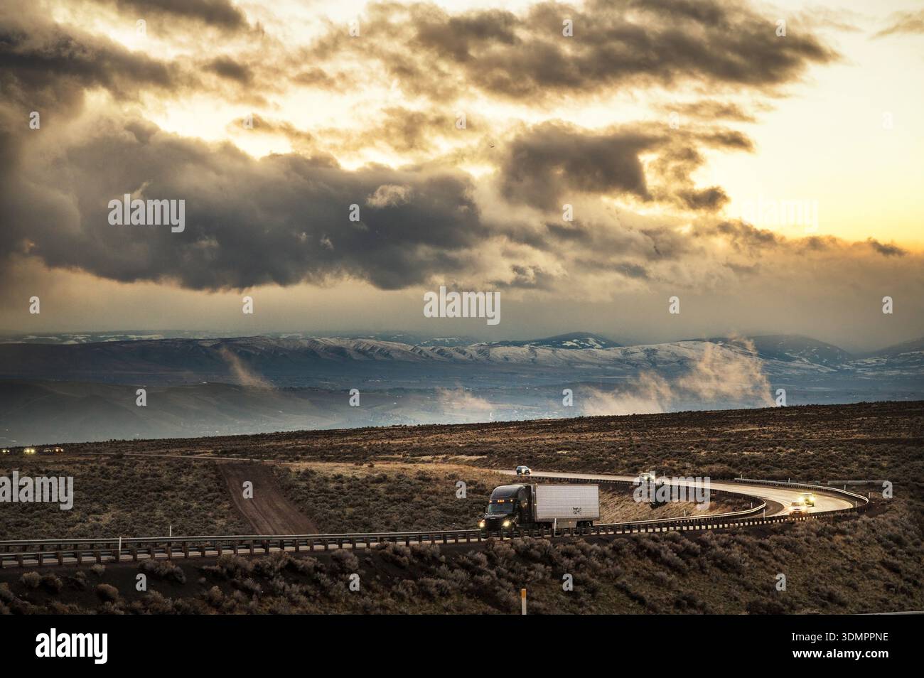 Le auto e gli autocarri per il trasporto di semitrattori attraversano una tempesta lungo l'Interstate 84. L'alto deserto vicino a Boise, Idaho, Stati Uniti. Foto Stock