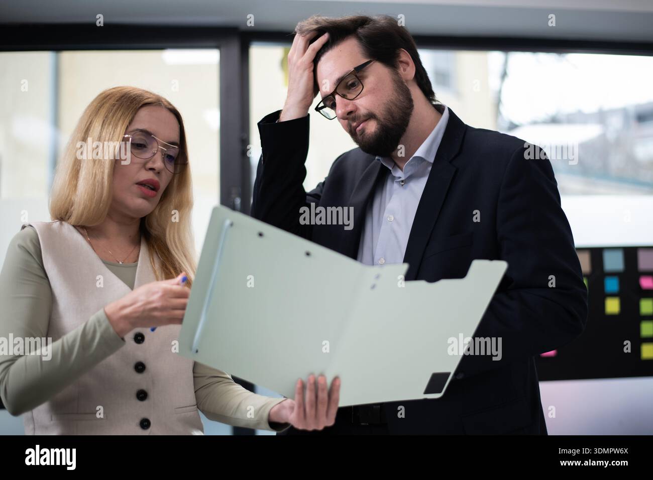 Colleghi che discutono di documenti durante una riunione sul luogo di lavoro in un ambiente di ufficio moderno Foto Stock