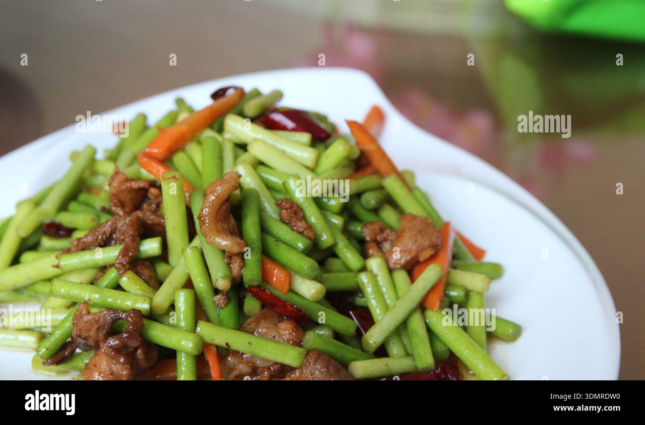 Steli cinesi all'aglio con carne di maiale e carote rosse in un ristorante, Zhangye City, Cina Foto Stock
