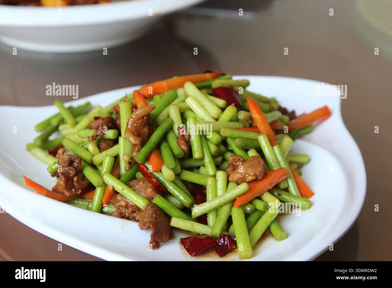 Steli cinesi all'aglio con carne di maiale e carote rosse in un ristorante, Zhangye City, Cina Foto Stock
