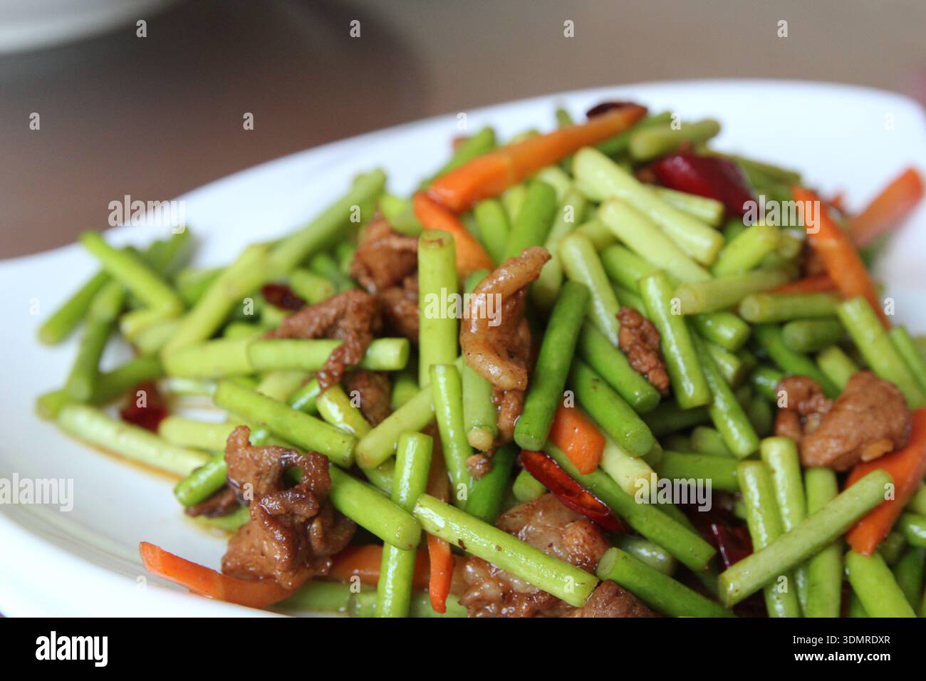 Steli cinesi all'aglio con carne di maiale e carote rosse in un ristorante, Zhangye City, Cina Foto Stock