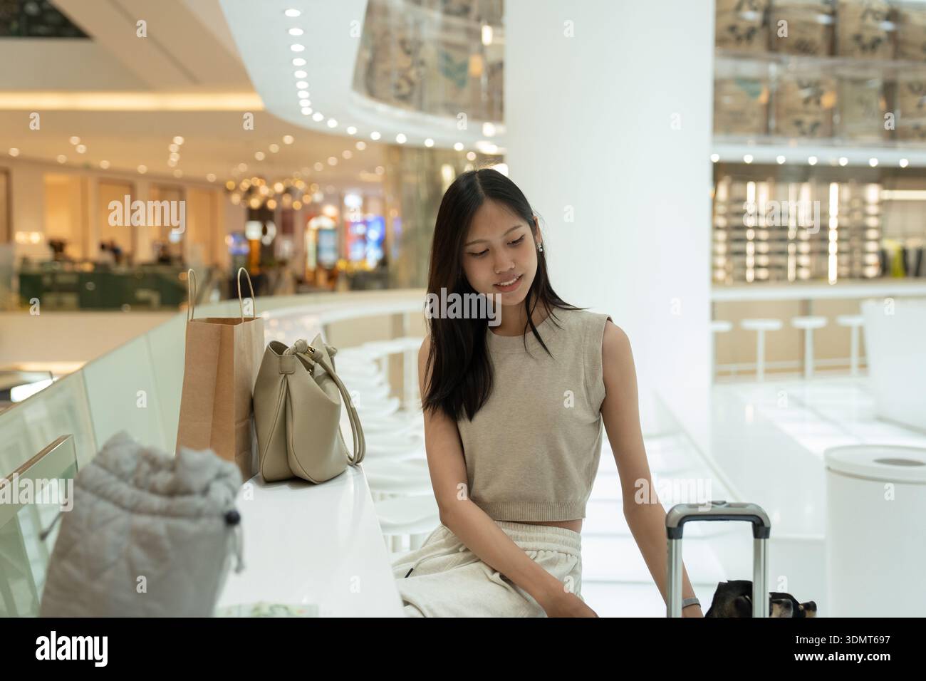 Giovane donna che fa shopping e viaggia in un centro commerciale moderno Foto Stock