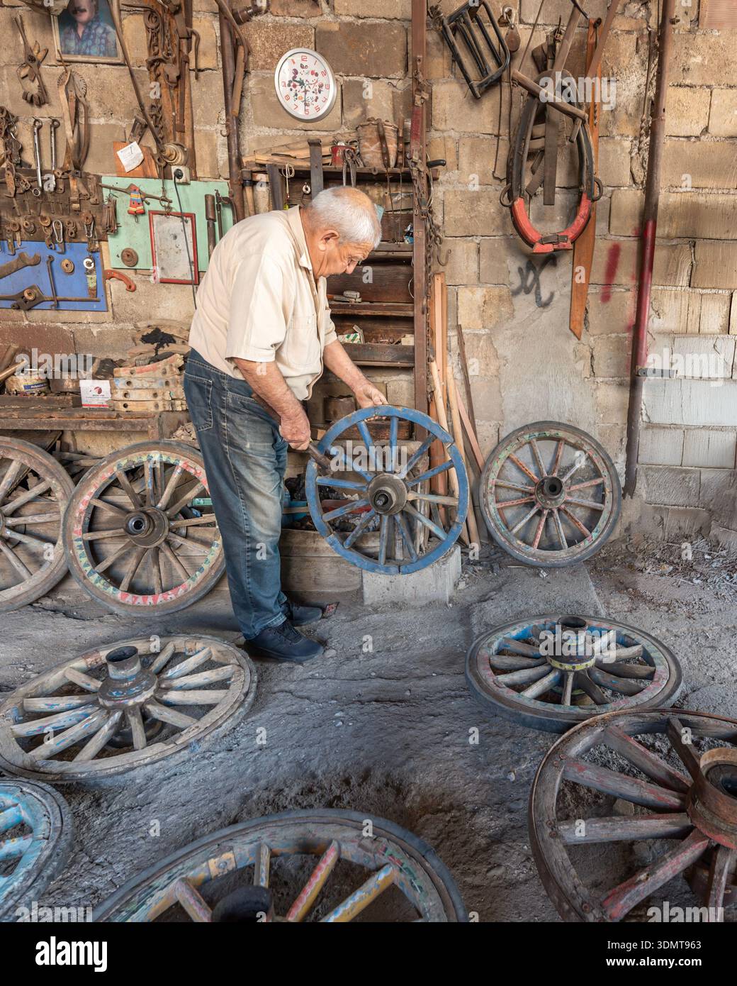 KULA, TURCHIA - 24 MAGGIO 2022: Maestro artigiano che ripara una ruota in legno nella sua storica officina a Kula, preservando il commercio tradizionale turco. Foto Stock