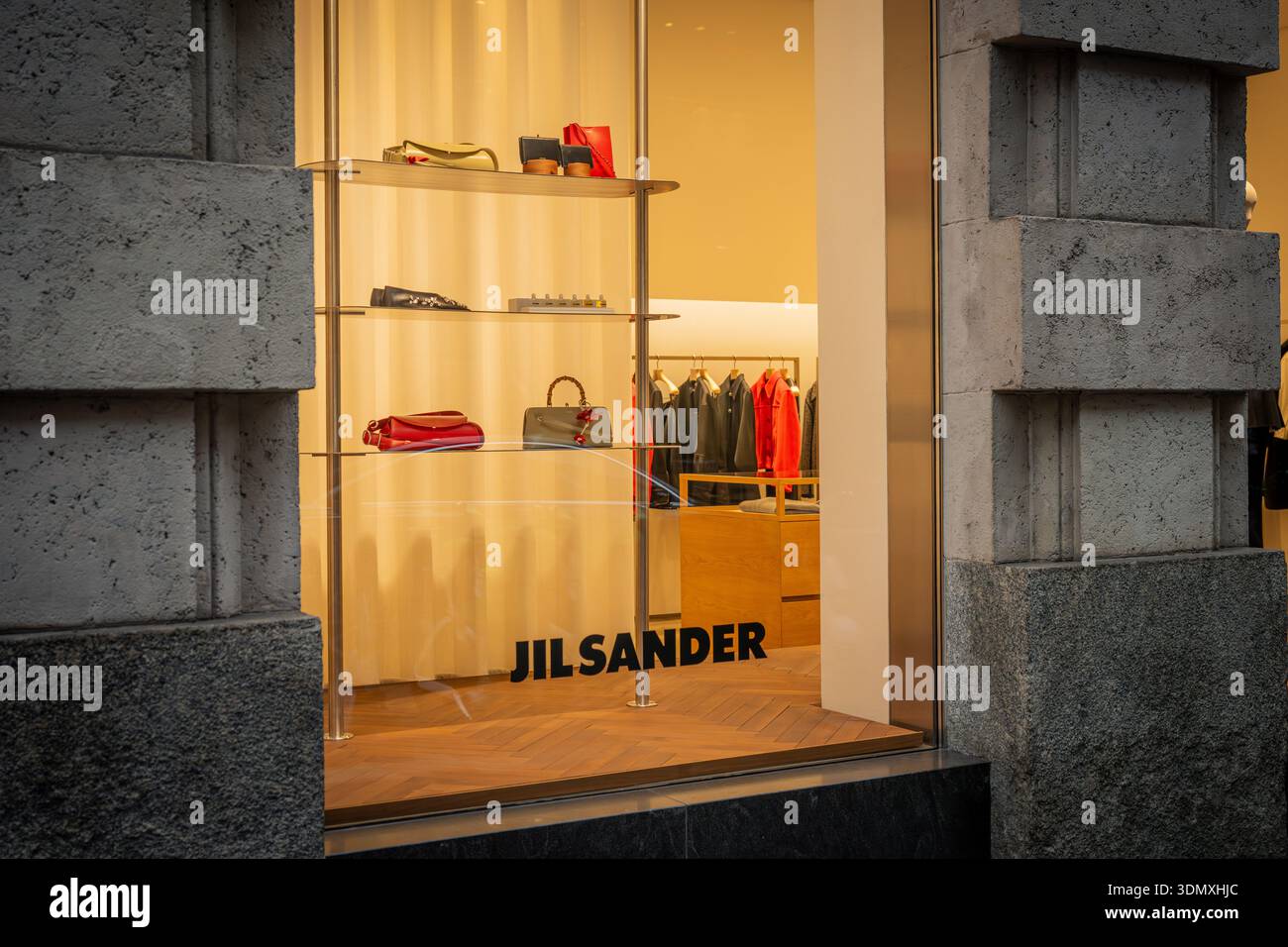 Milano, Italia - 2026, 3 Feb: Vetrina boutique Jil Sander FW25 espone borse e accessori di lusso in un ambiente chic e minimalista, mettendo in risalto il moder Foto Stock