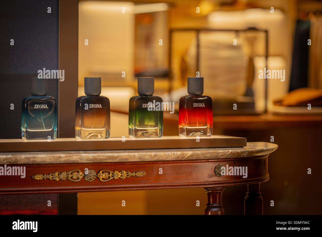 Milano, Italia - 2026, 3 Feb: Collezione di fragranze Zegna FW25 esposta su un tavolo in marmo, che mette in mostra colori vivaci e design di lusso in un ambiente elegante Foto Stock