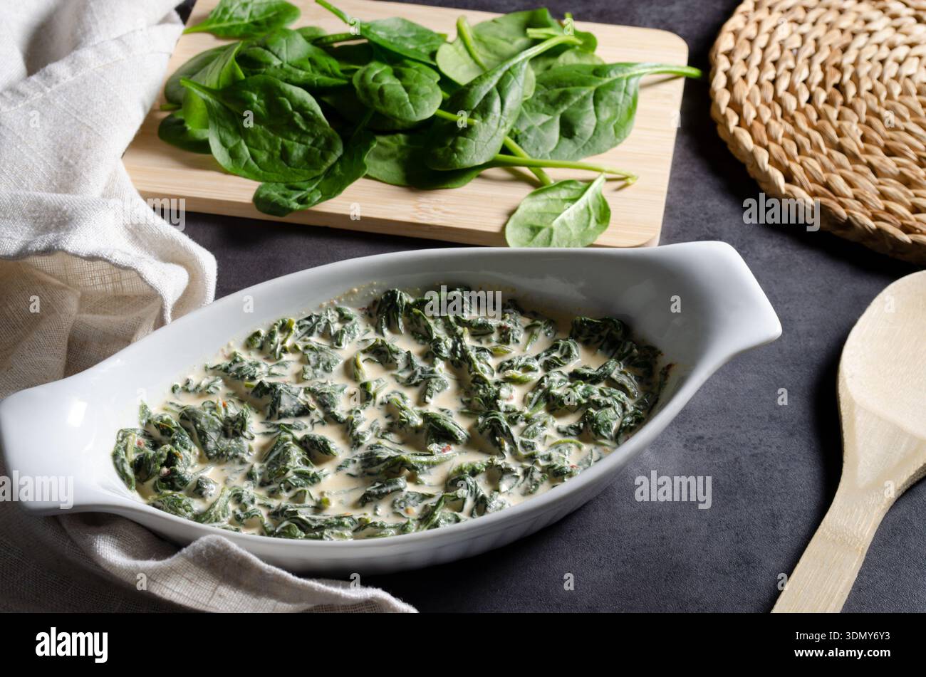 Una crema di spinaci servita in un piatto bianco, con teneri foglie di spinaci in una salsa morbida, formaggio e cremosa infuso di aglio. Perfetto per qualsiasi pasto. Foto Stock