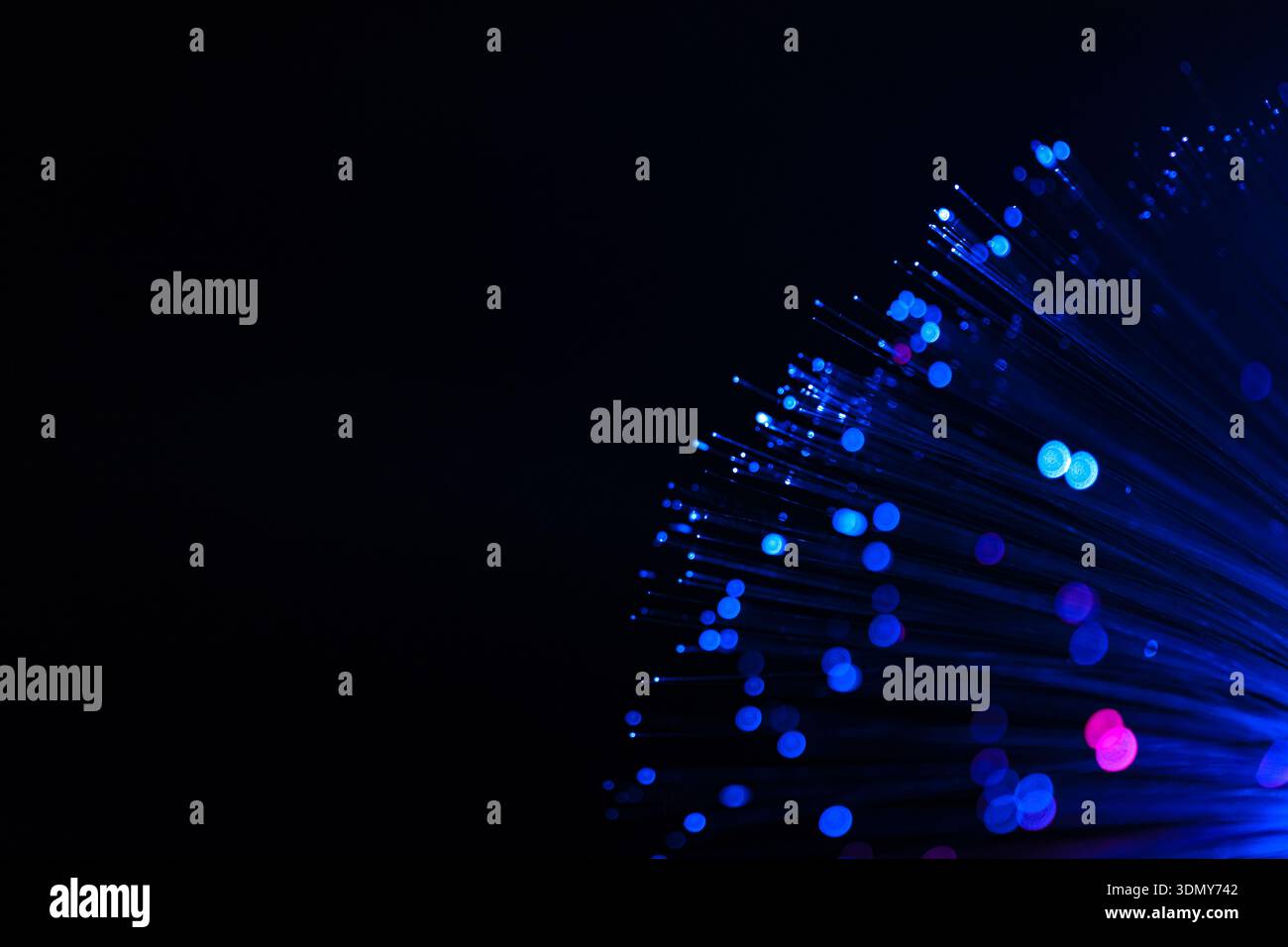 Immagine astratta con un'accattivante esposizione di luci al neon che proiettano vivaci macchie blu su uno sfondo scuro, creando un effetto modico accattivante Foto Stock