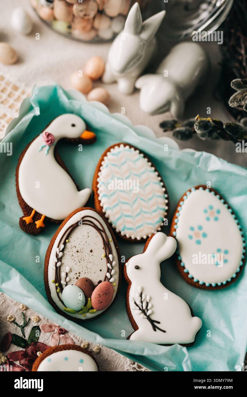 I biscotti pasquali, a forma di uova, coniglietti e anatre, sono splendidamente ghiacciati e circondati da motivi primaverili. Ideale per feste e feste Foto Stock