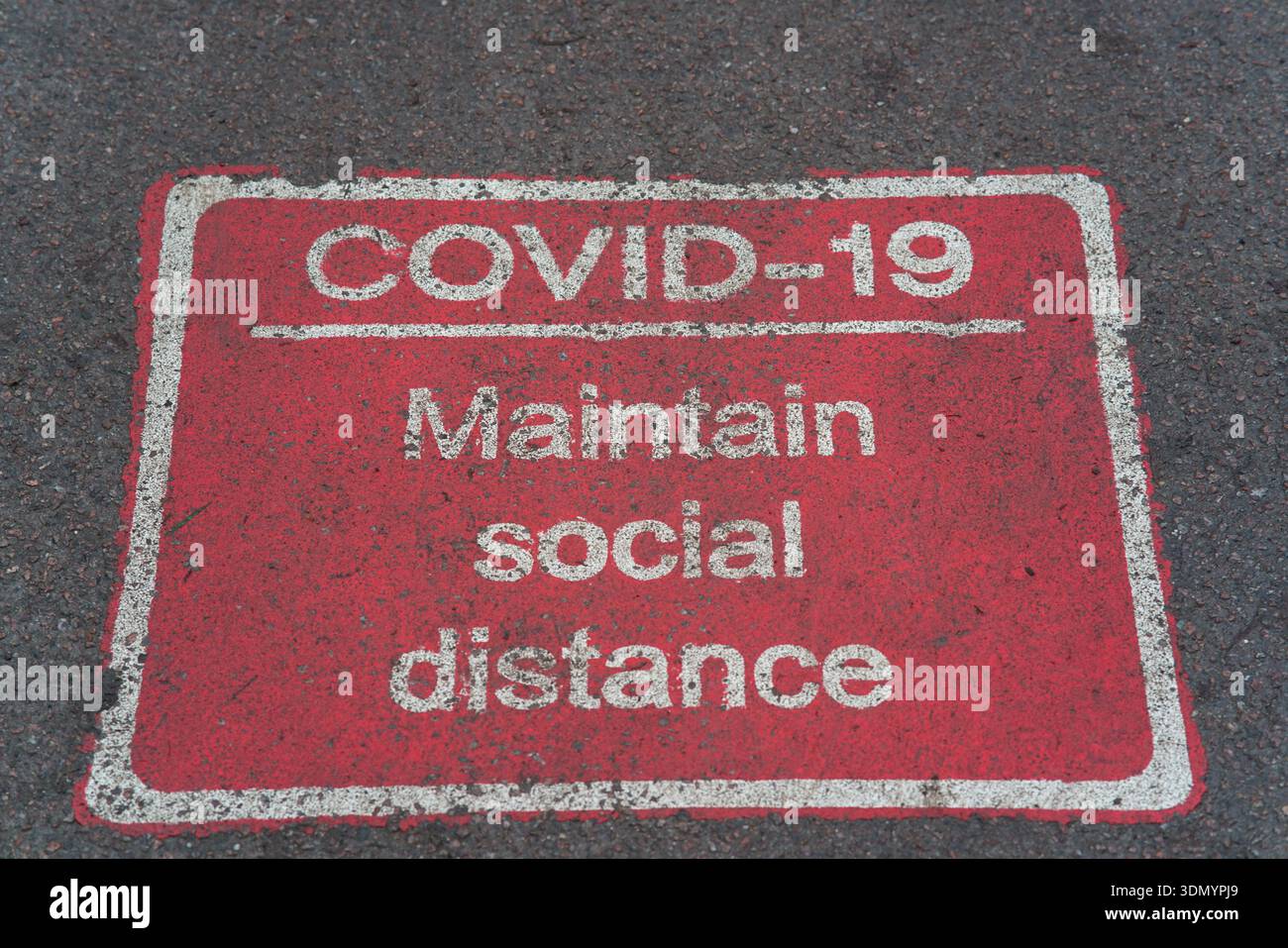 Segnale di pavimentazione "mantenere la distanza sociale" per la COVID-19 sbiadita sulla strada di Cambridge.Cambridge, Inghilterra Foto Stock