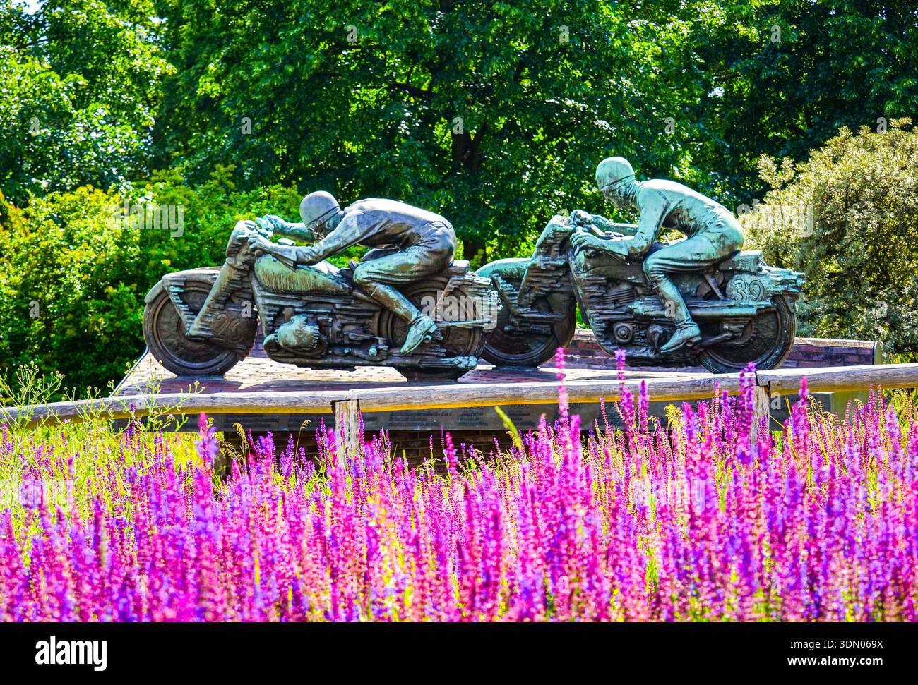 Monumento in bronzo al motociclista, incorniciato da epilobi viola, storia delle corse AVUS, Berlino Foto Stock
