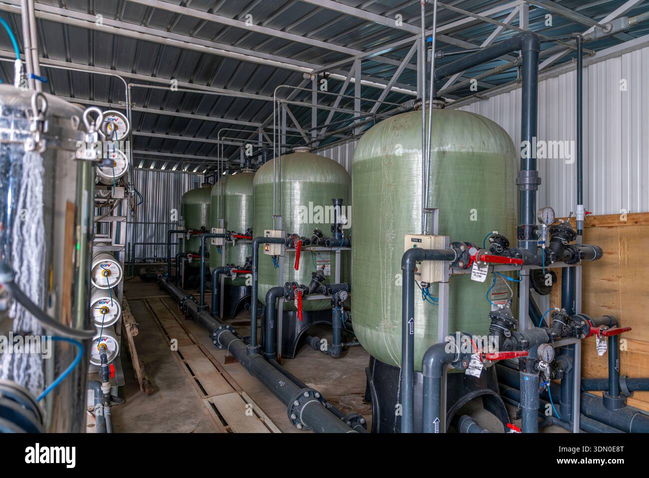 Sistema di trattamento delle acque industriale con serbatoi per terreni filtranti, valvole, manometri e tubazioni all'interno dell'impianto di trattamento. Foto Stock