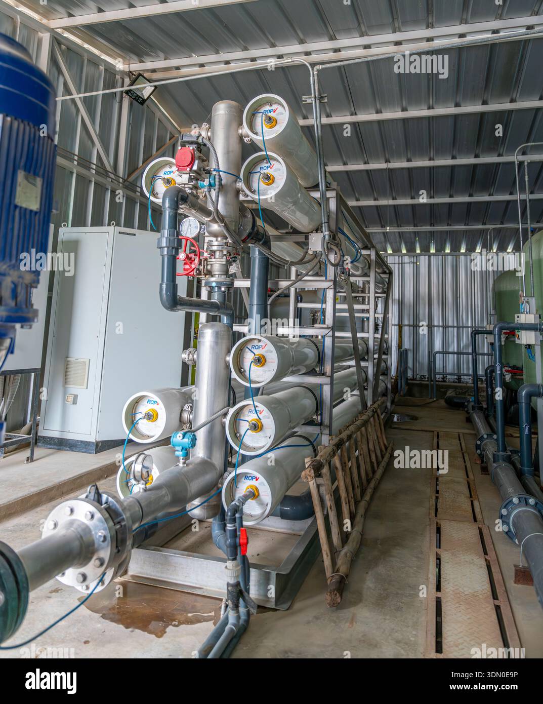 Sistema di trattamento industriale delle acque a osmosi inversa con alloggiamenti a membrana, tubi, valvole e serbatoio all'interno dell'impianto di trattamento. Foto Stock