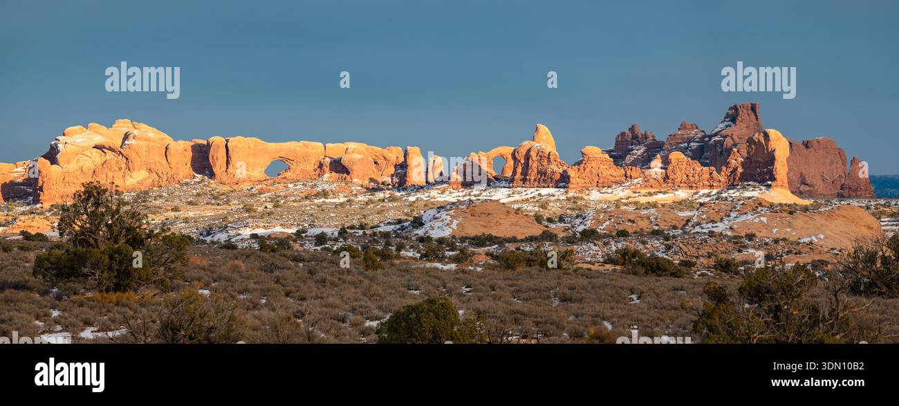 Questo splendido panorama invernale all'Arches National Park presenta la sezione Windows, che include l'Arco della torretta accentuato dalla luce soffusa al tramonto, Foto Stock