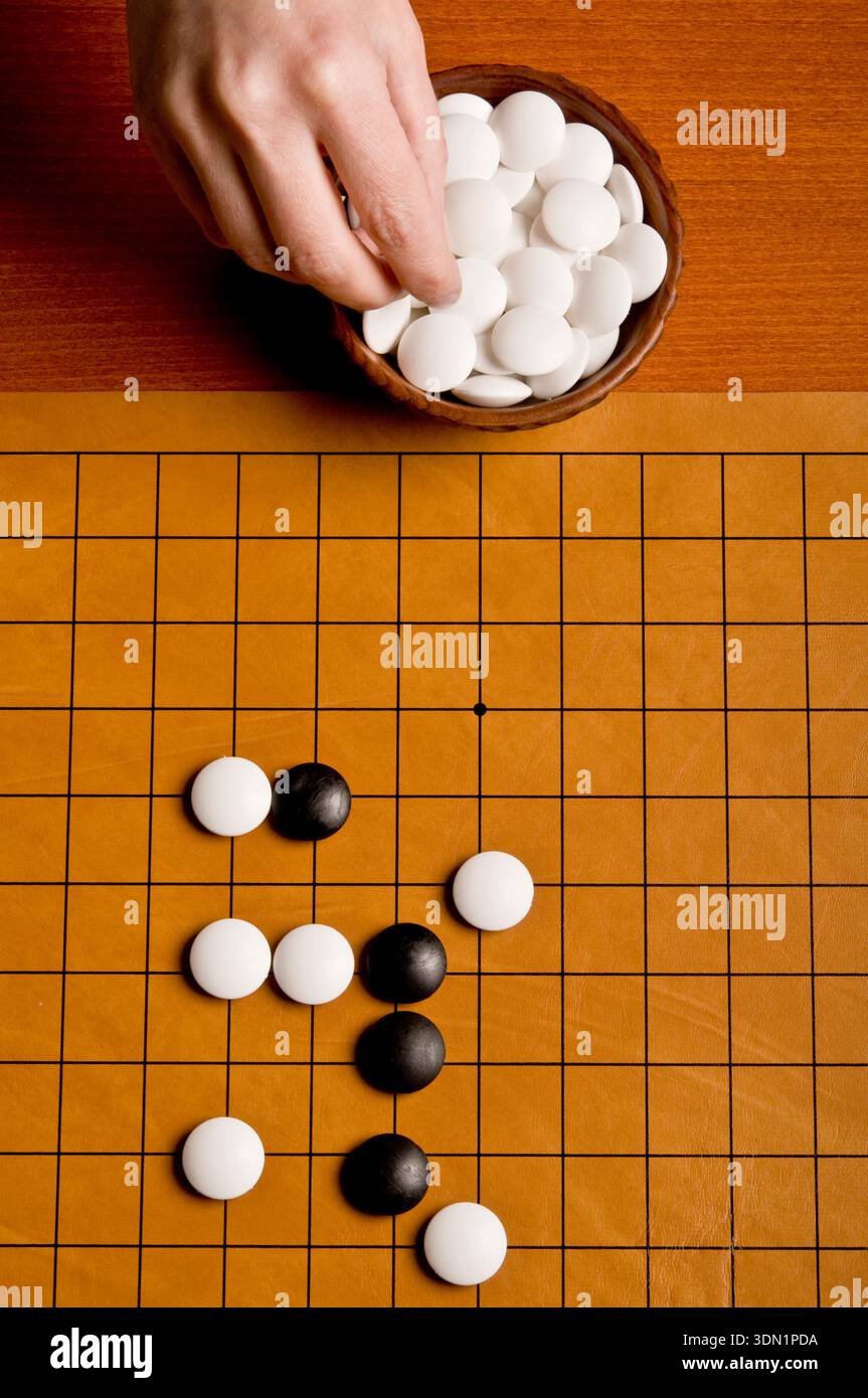 giocatore di go pronto a giocare una pietra Foto Stock
