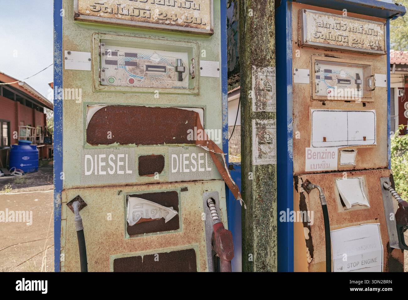 Stazione di servizio tailandese abbandonata: Pompe d'epoca con insegne tailandesi e inglesi sbiadite diesel e benzina sull'isola deserta di Koh Kho Khao, Thailandia Foto Stock