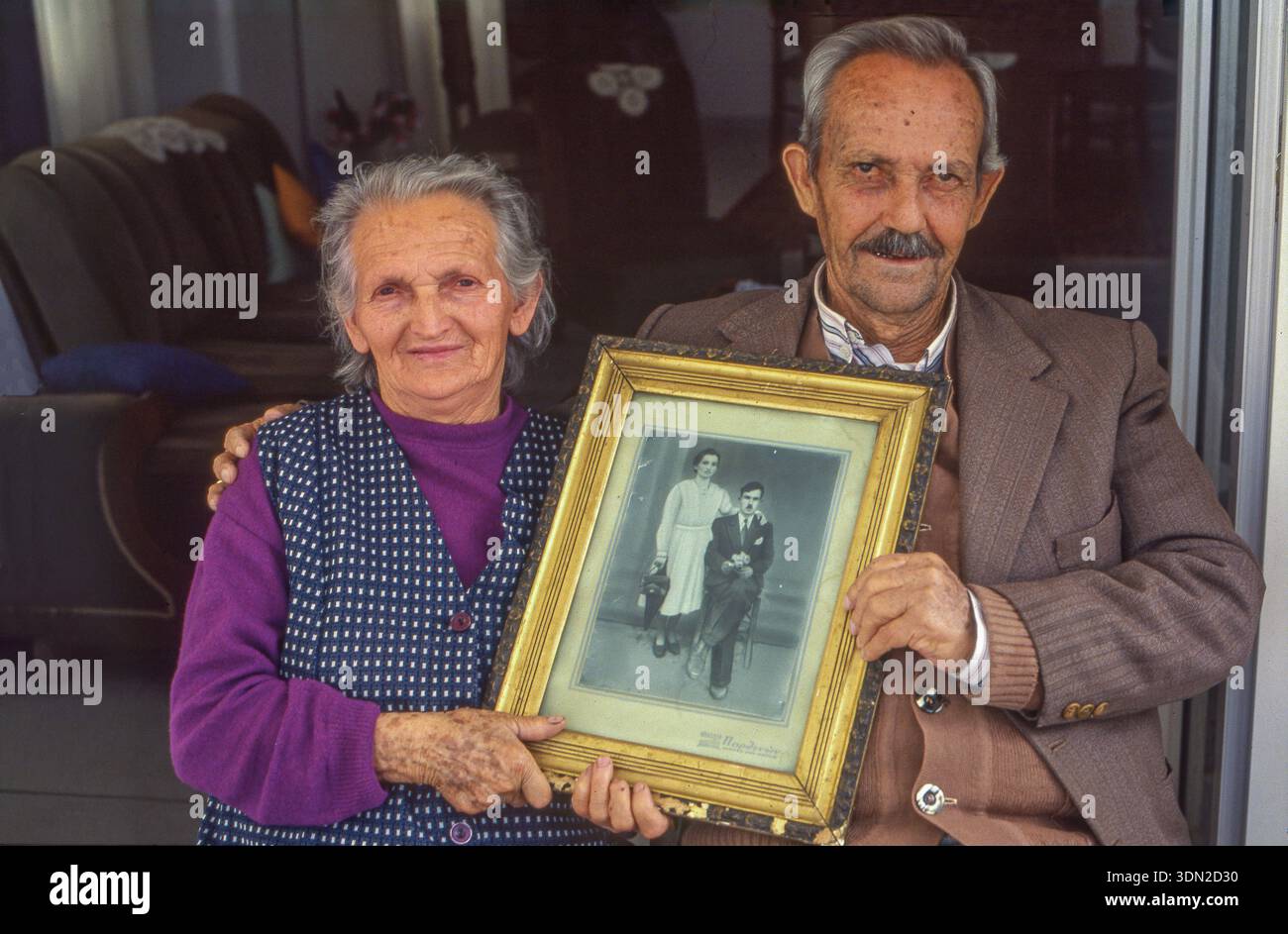 Grecia, isola di Egina, coppia anziana con foto vintage in bianco e nero incorniciata del loro matrimonio 50 anni fa. Foto Stock