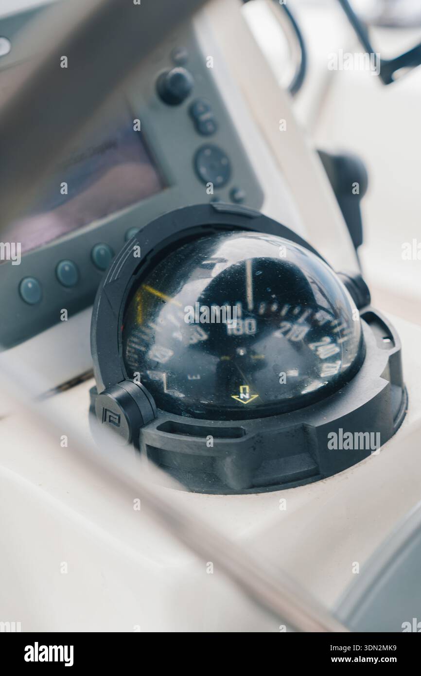 Navigazione con bussola marina e display elettronico sull'imbarcazione Foto Stock