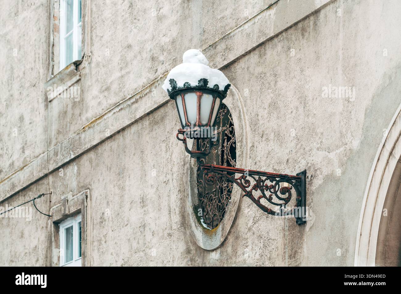 Ornata lanterna da parete d'epoca innevata nella città vecchia d'inverno, attenzione selettiva Foto Stock