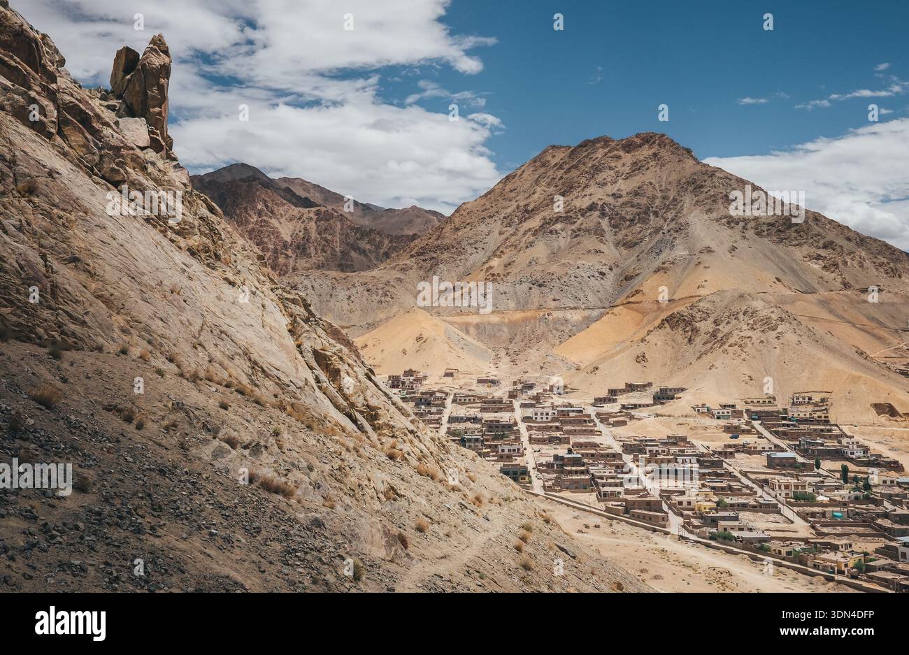 Vista panoramica dall'alto angolo della città di Leh, annidata nell'aspra valle montana dell'Himalaya sotto il cielo blu con nuvole bianche nella regione del Ladakh, nel nord dell'India Foto Stock