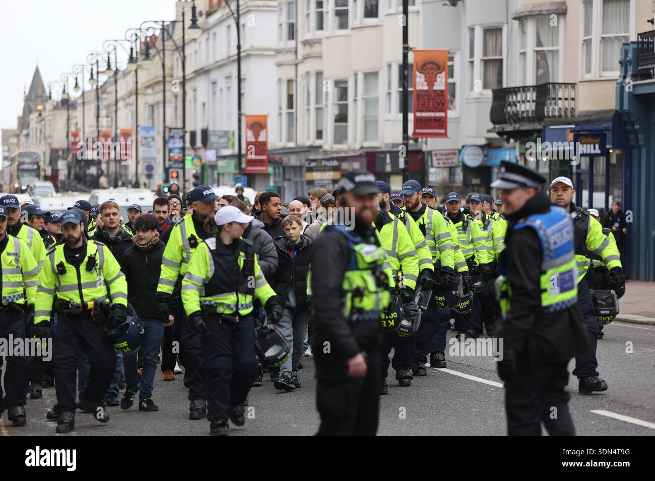 Brighton, Regno Unito. 8 febbraio 2026. I tifosi del Crystal Palace sono scortati dalla polizia del Sussex attraverso il centro di Brighton verso la stazione ferroviaria, prima dello scontro derby con Brighton e Hove Albion all'Amex Stadium. Ufficiali, unità a cavallo e cani della polizia sono stati schierati per tenere separati i tifosi rivali prima del calcio d'inizio. Crediti: Sussex News/Alamy Live News Foto Stock