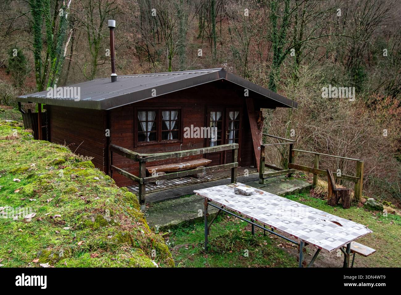 Piccola cabina in legno con tavolo da picnic in un tranquillo ambiente della campagna forestale Foto Stock