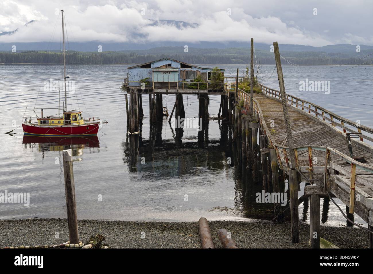 Casa su palafitte con molo e barca sull'Oceano Pacifico, Alert Bay, British Columbia Foto Stock